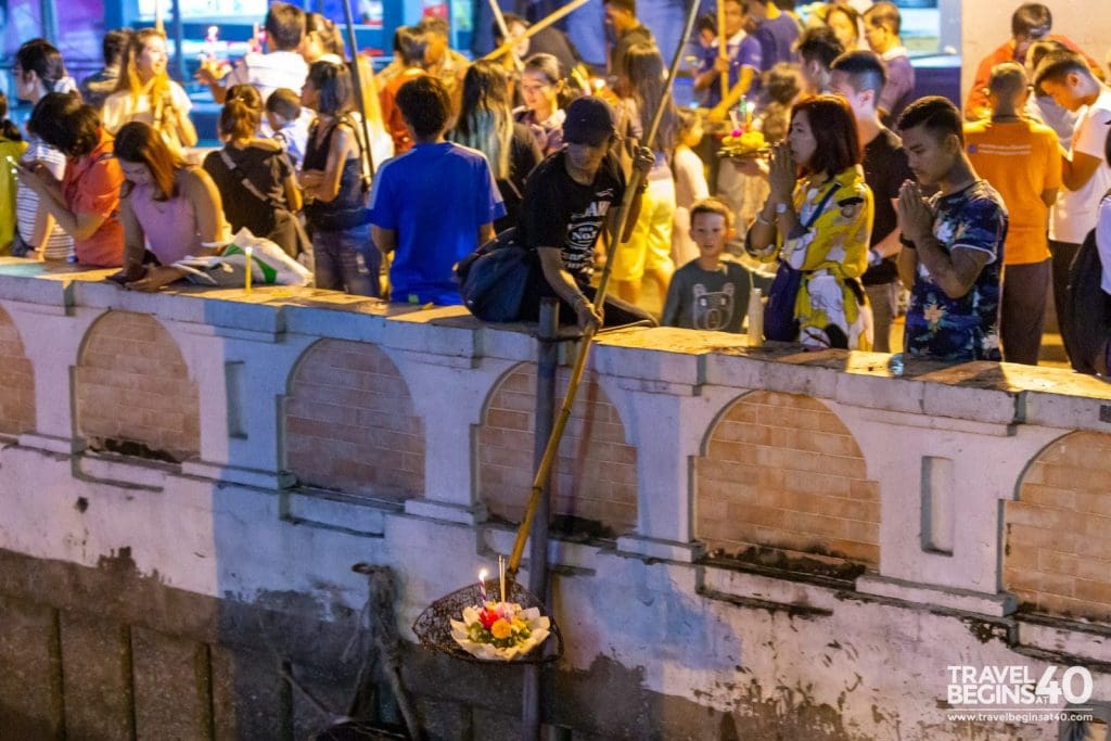 Lowering Krathongs into the Chao Phraya river at Saphan Taksin in Bangkok