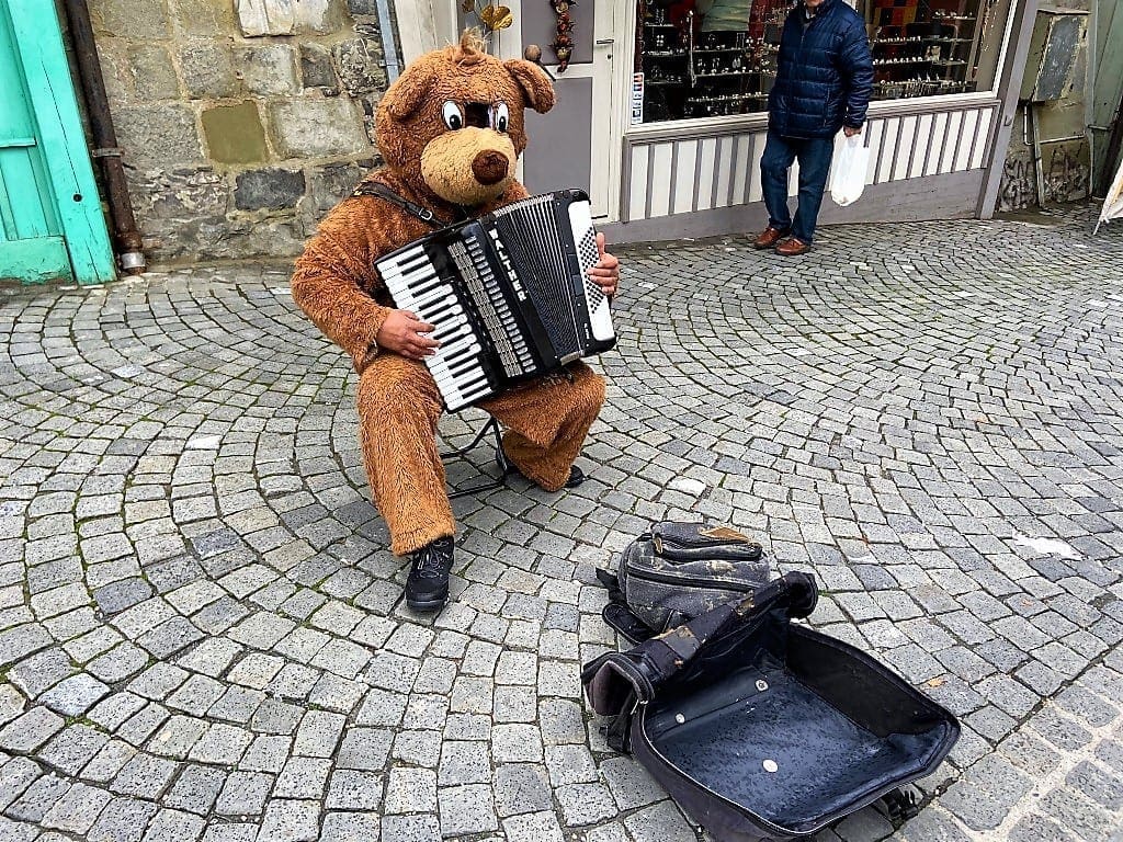 Teddy bear plating the accordion at the Lausanne market