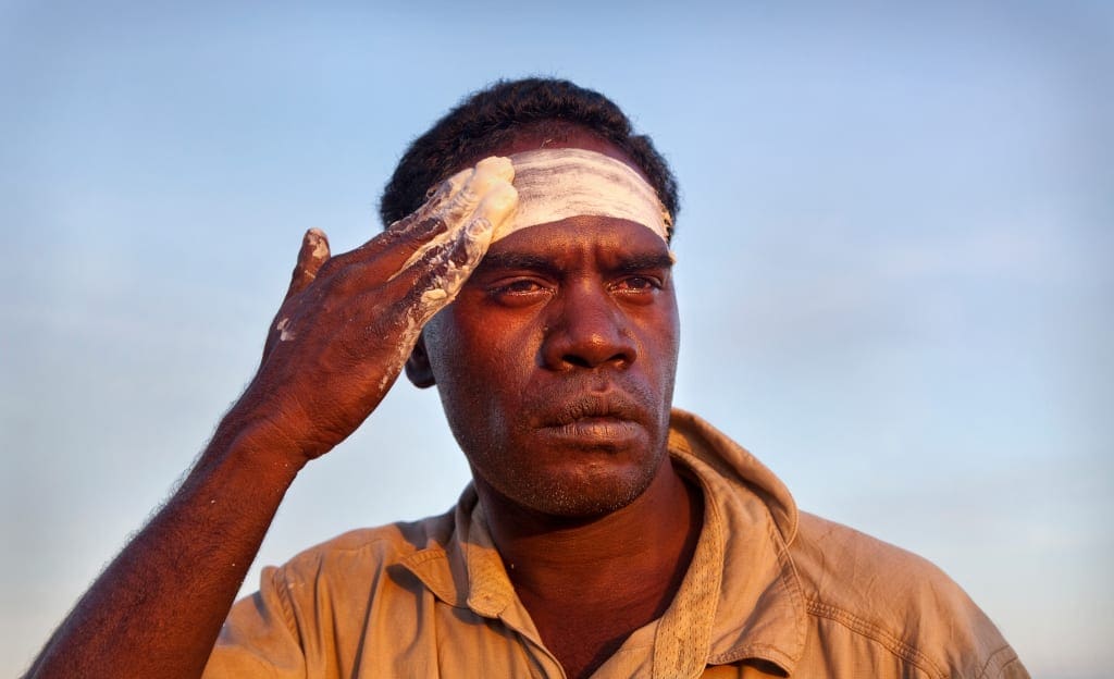 Portrait, Aboriginal man applying welcome clay.
