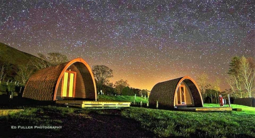 Camping pods at night at the Quiet Site