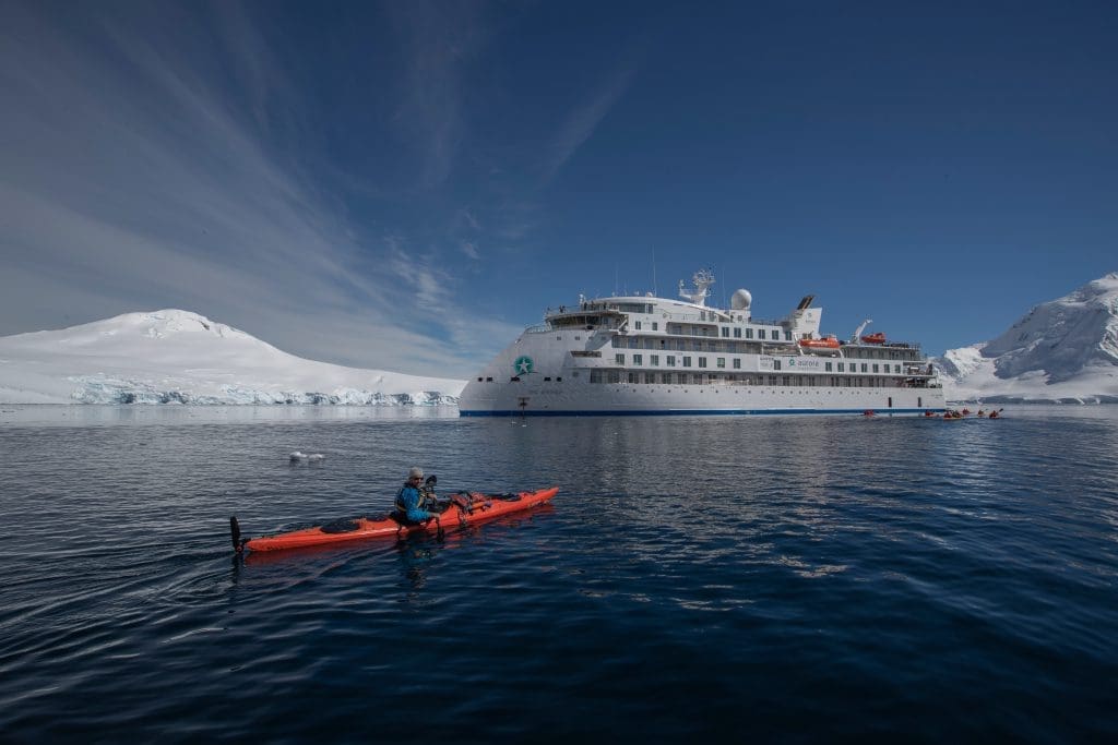 Kayaker In Front of the Greg Mortimer, Antarctica; Scott Portelli