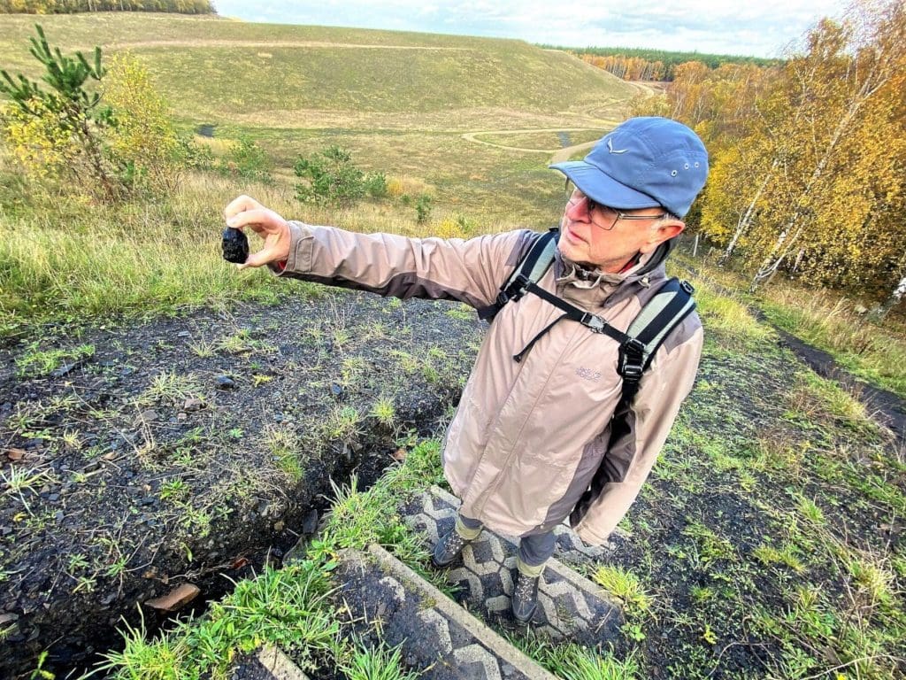 Robert holding a piece of coal in the Hoge Kempen National Park