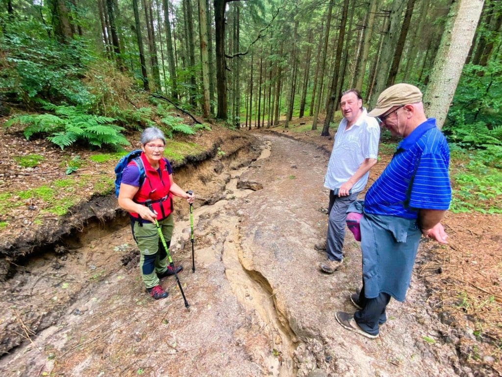 Kirsten (l) explains how recent rains have eroded the path