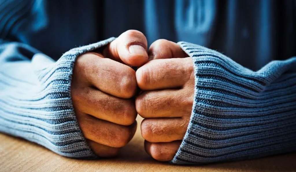 Clenched hands in a sweater showing stress