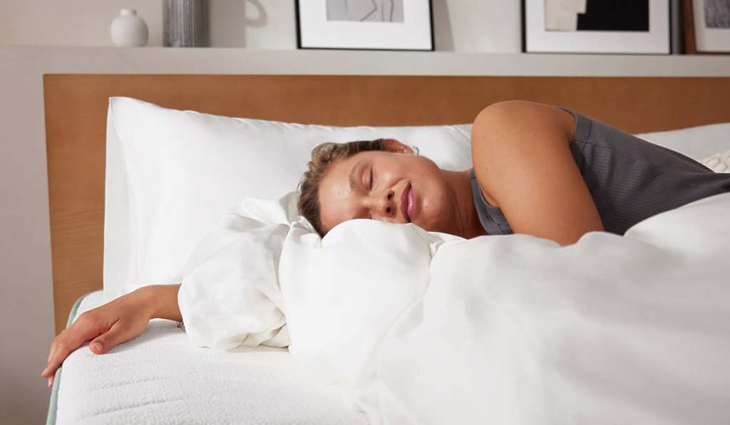 Person sleeping peacefully on white bedding