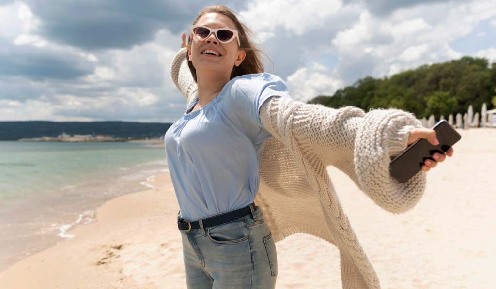 Cheerful woman enjoying breezy beach day