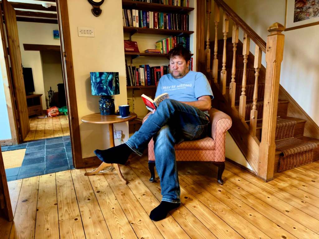 Mark chilling with a book in the cottage